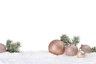 Photo of Beautiful Christmas balls and fir tree branches on snow against white background