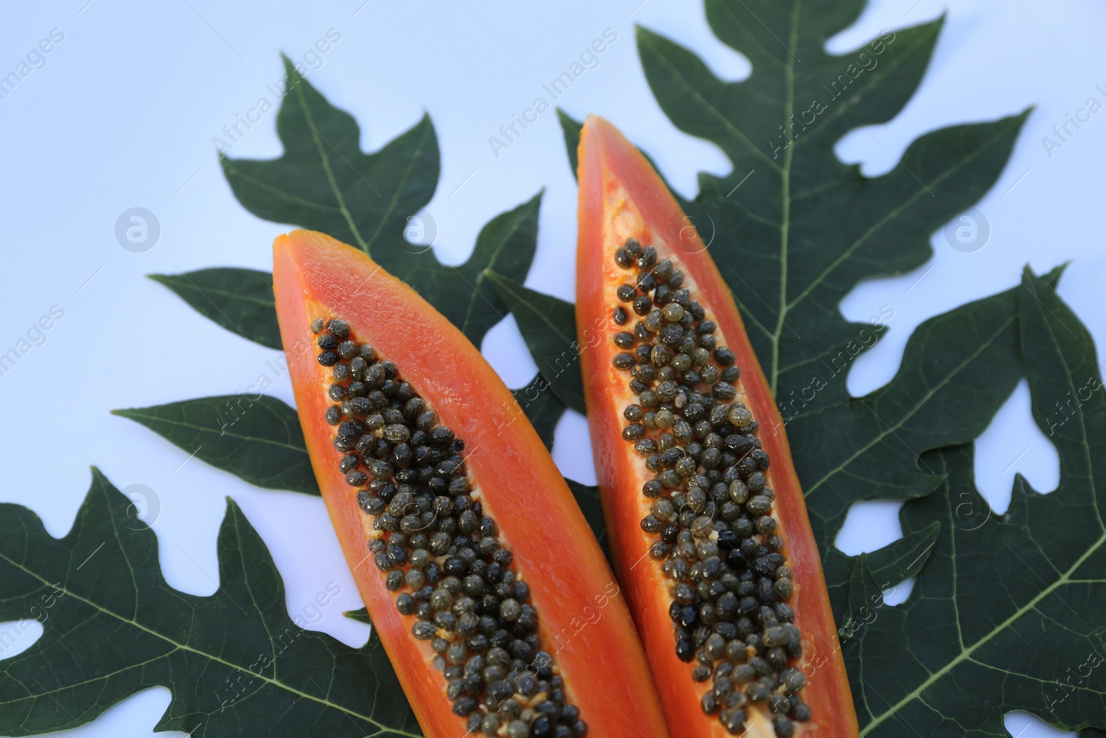 Photo of Fresh ripe papaya slices with leaf on white background, flat lay