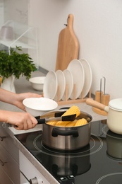 Photo of Woman preparing corn in stewpot on stove, closeup