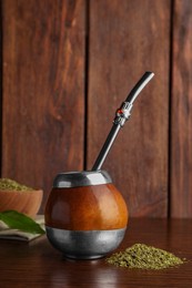 Photo of Calabash with mate tea and bombilla on wooden table