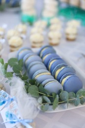 Photo of Delicious sweet blue macarons served on table