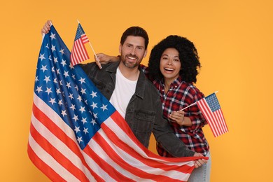 Photo of 4th of July - Independence Day of USA. Happy couple with American flags on yellow background