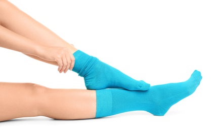 Woman putting on stylish socks on white background, closeup