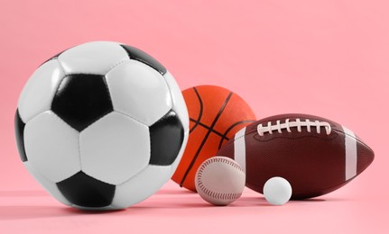 Photo of Many different sports balls on pink background