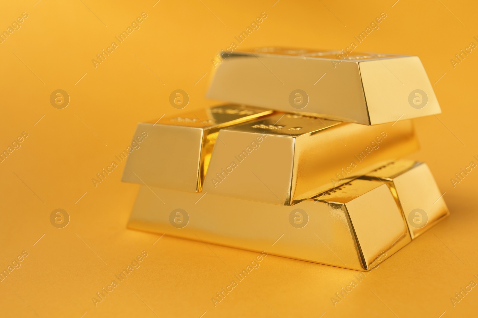 Photo of Precious shiny gold bars on color background