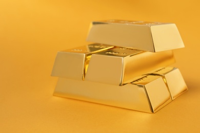 Photo of Precious shiny gold bars on color background