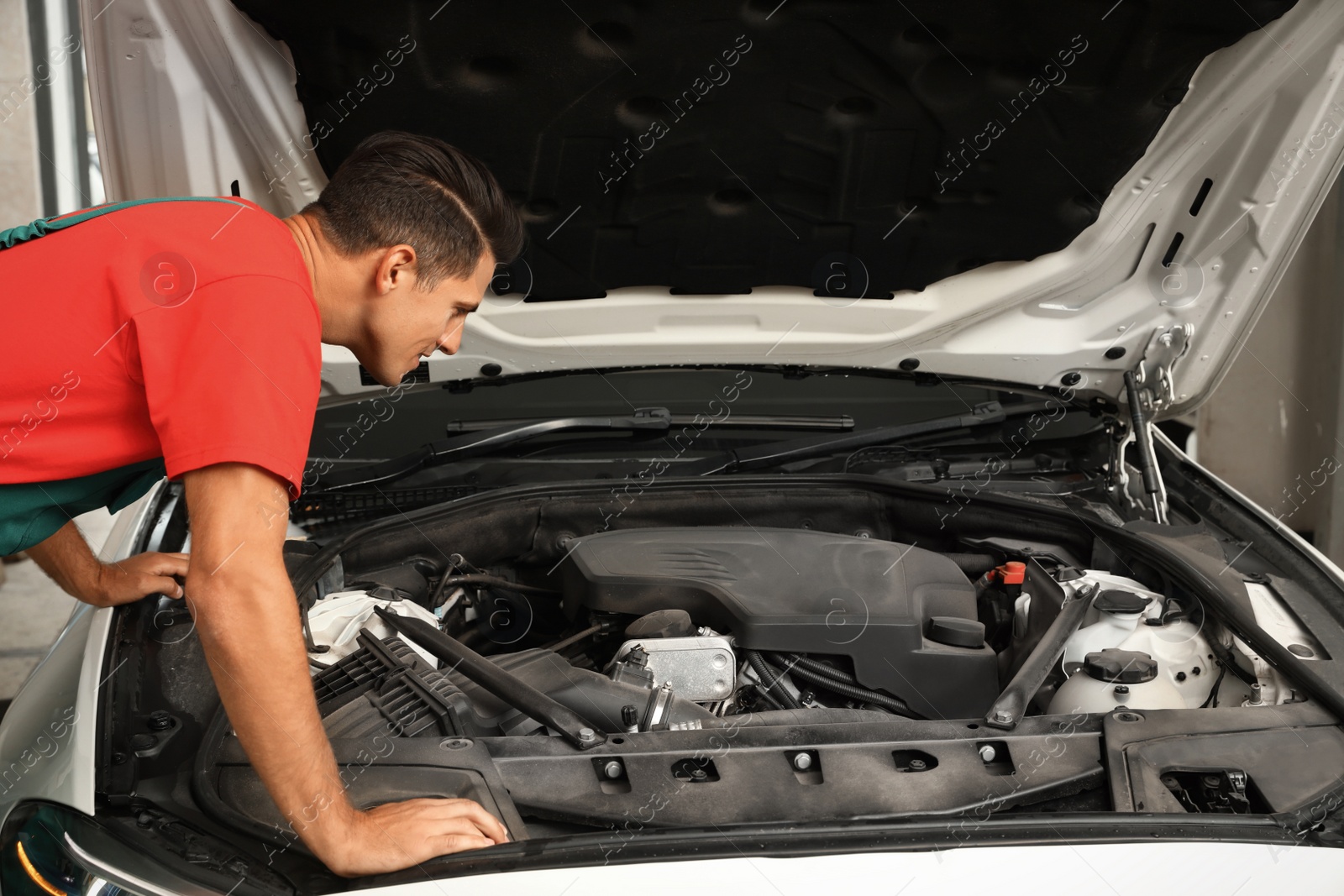 Photo of Professional mechanic checking modern car at automobile repair shop