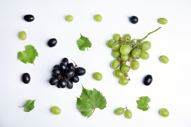 Photo of Fresh ripe juicy grapes and leaves on white background, top view