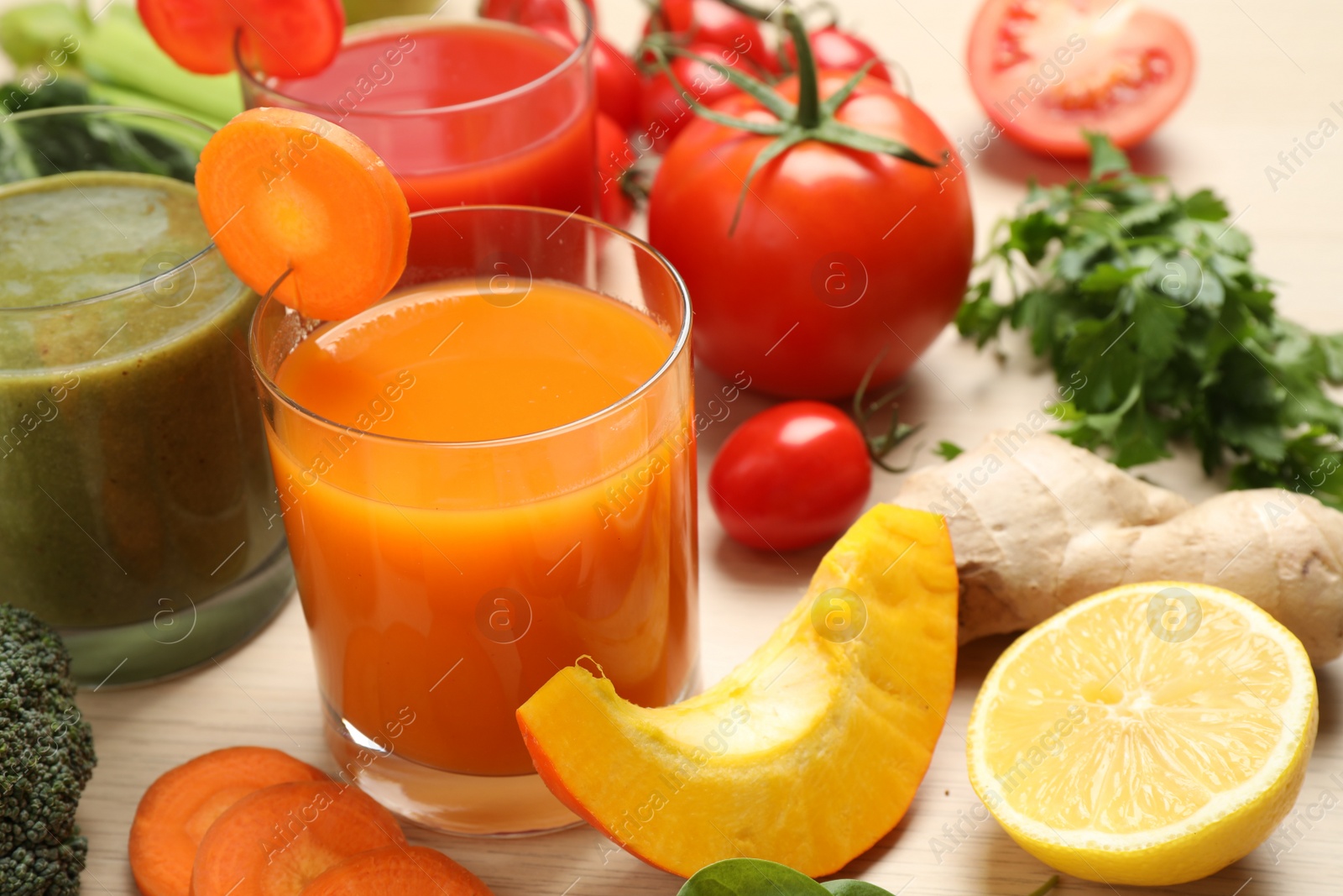 Photo of Delicious vegetable juices and fresh ingredients on wooden table