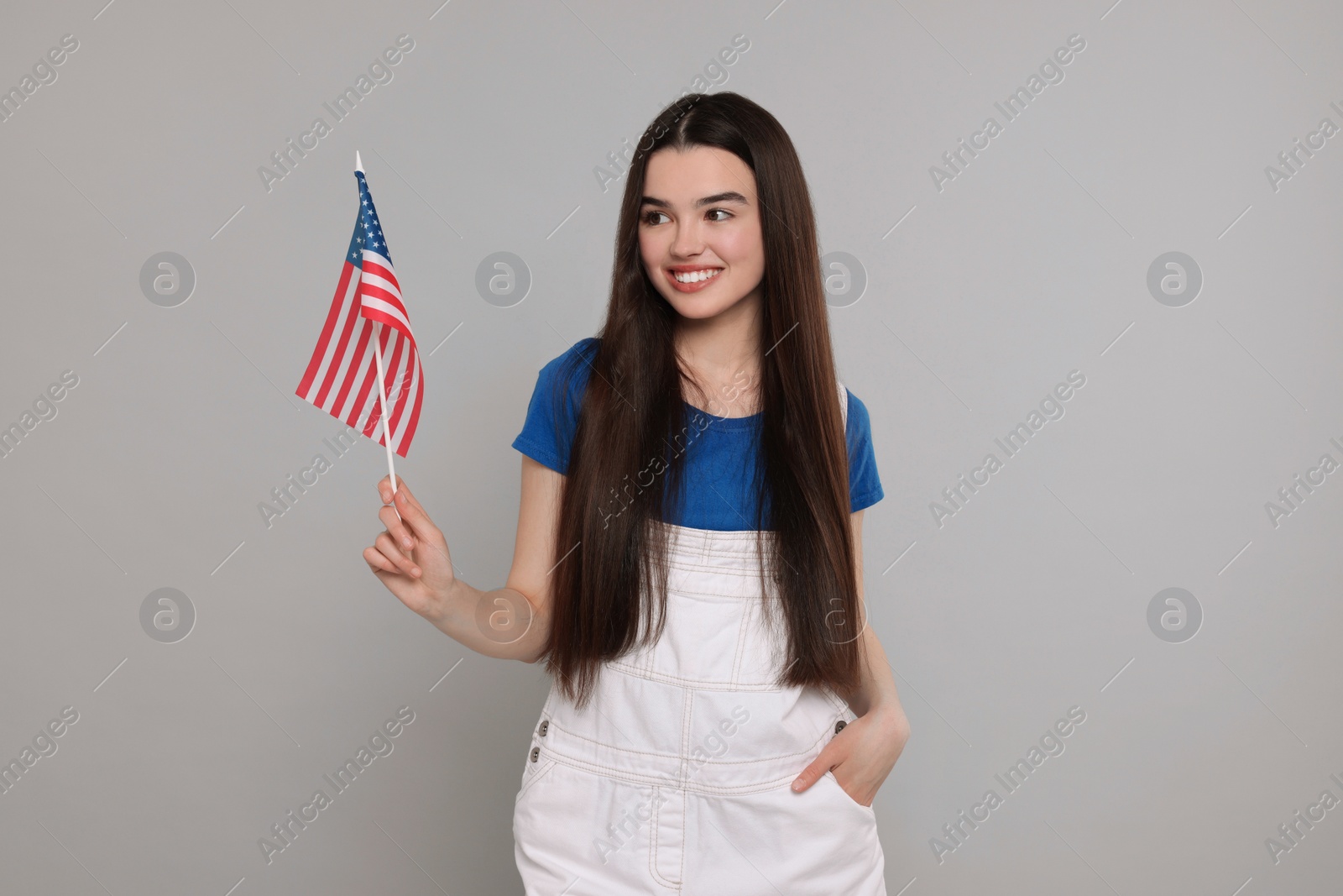 Photo of 4th of July - Independence Day of USA. Happy girl with American flag on grey background