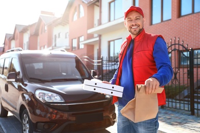 Male courier delivering food in city on sunny day