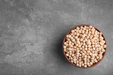 Photo of Bowl with dried peas on grey background, top view