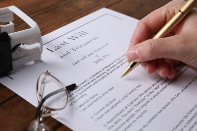 Photo of Woman signing Last Will and Testament at wooden table, closeup