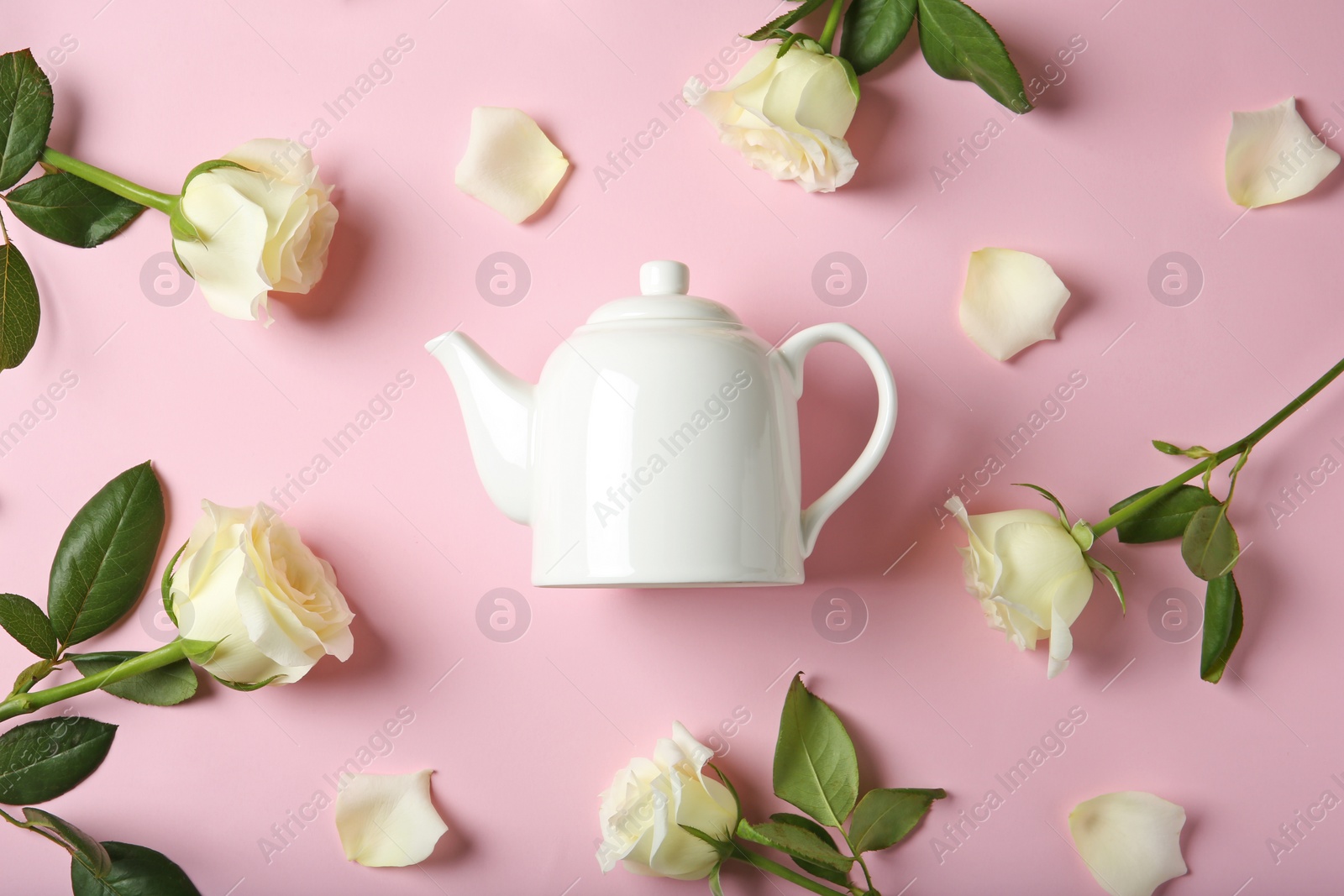 Photo of Flat lay composition with teapot and roses on color background