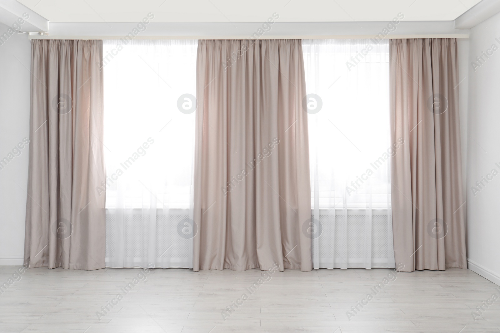 Photo of Windows with elegant curtains in empty room