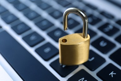 Photo of Metal padlock on laptop keyboard, space for text. Cyber security concept