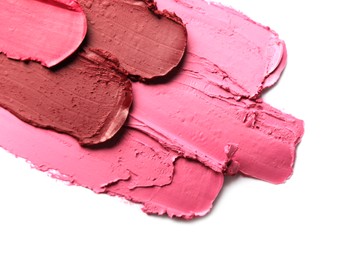 Smears of bright lipsticks on white background, top view