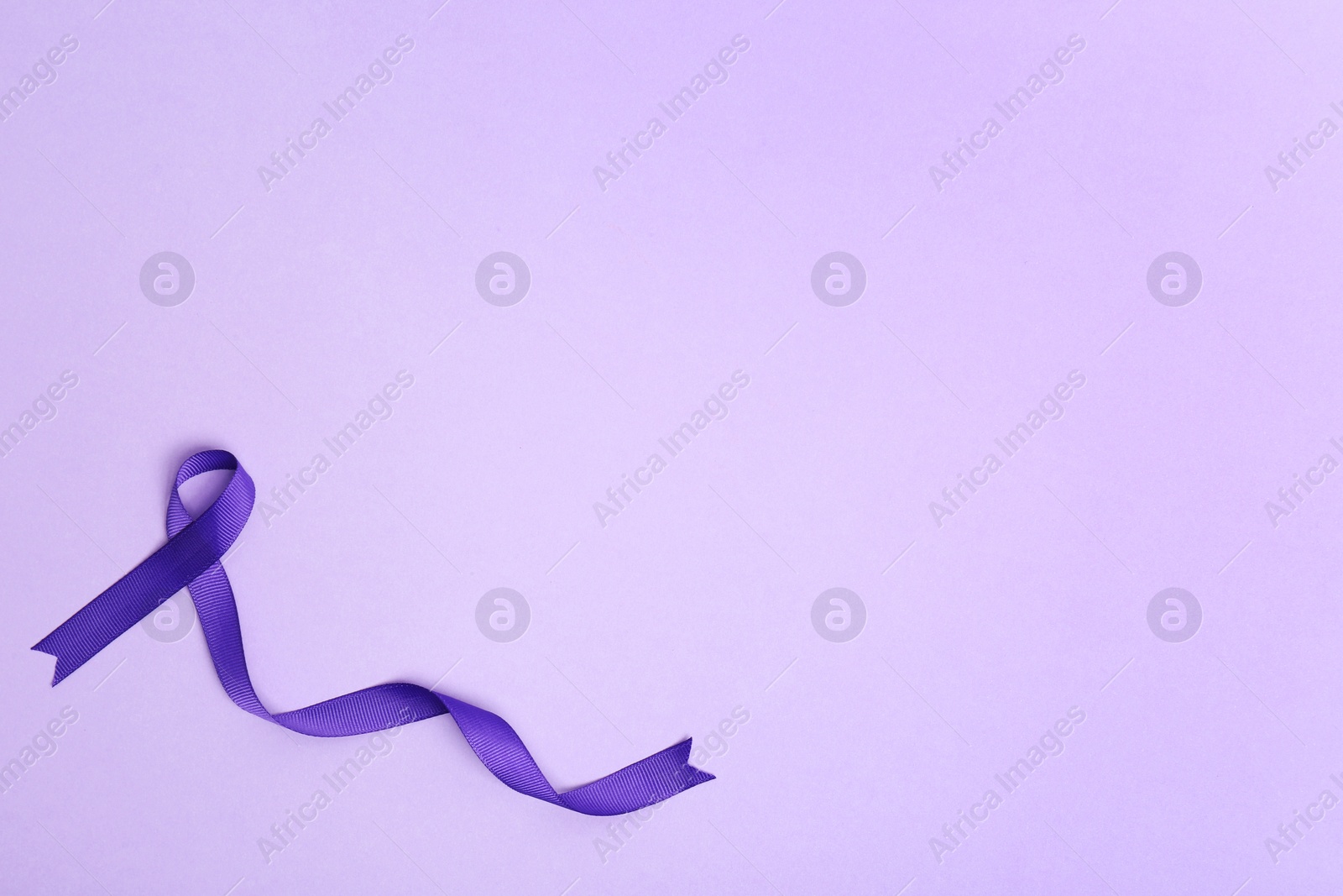 Photo of Purple awareness ribbon on lilac background, top view with space for text