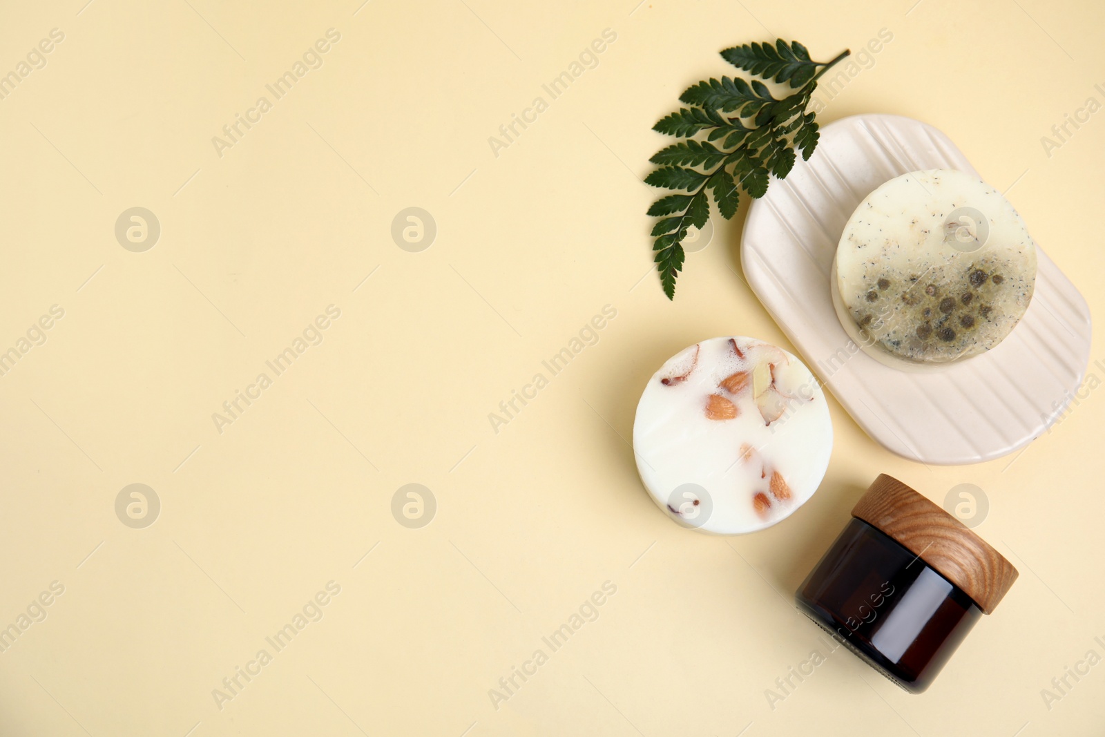 Photo of Eco friendly personal care products and green leaf on beige background, flat lay. Space for text