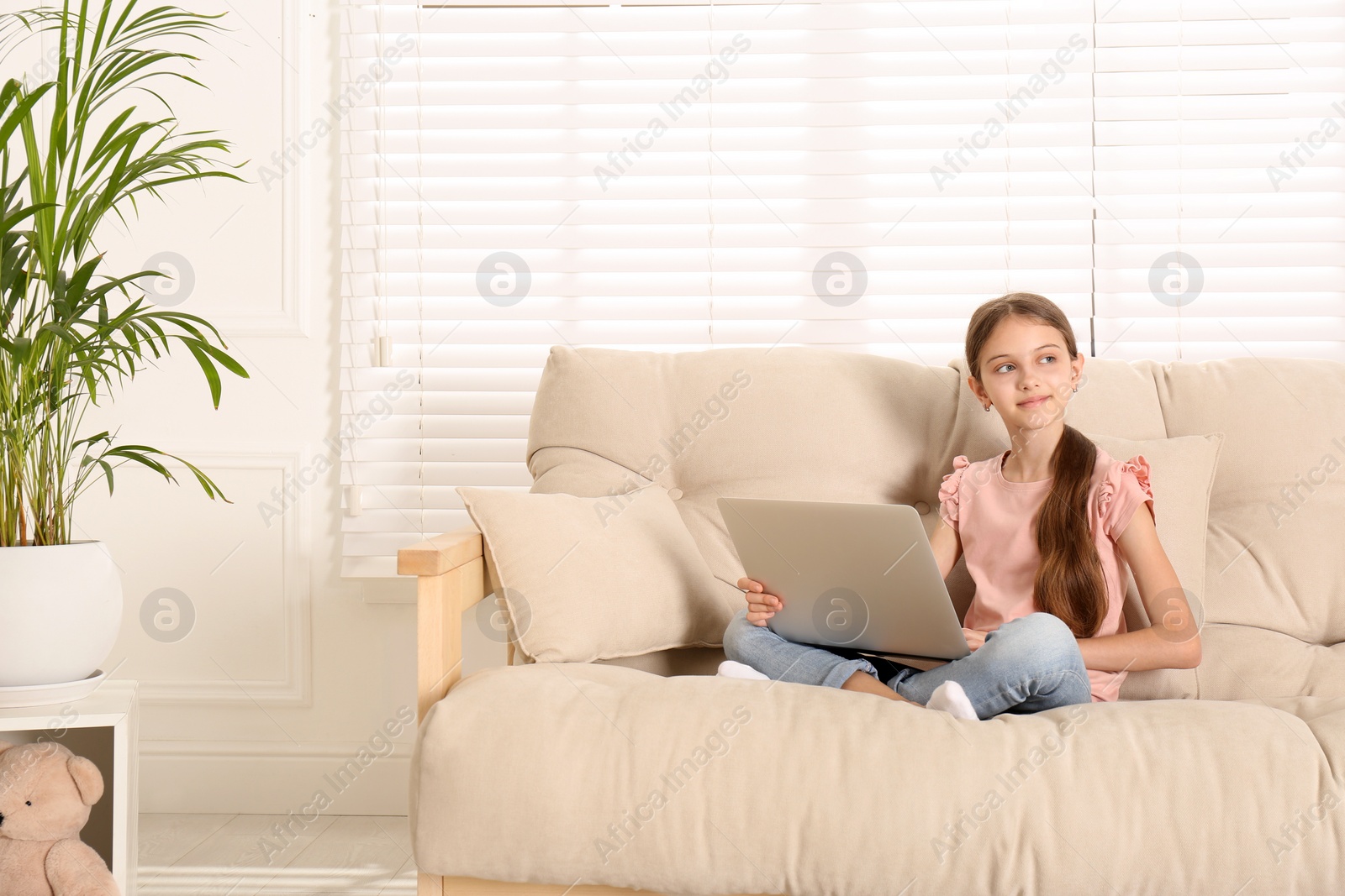 Photo of Thoughtful girl with laptop on sofa at home