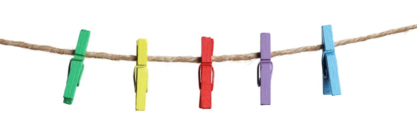 Photo of Many colorful wooden clothespins on rope against white background