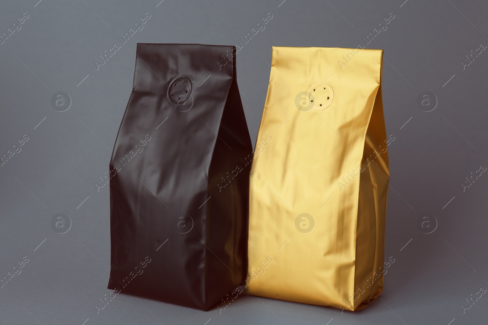 Photo of Different blank foil packages on grey background