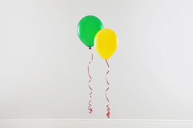 Different bright balloons against light wall. Celebration time