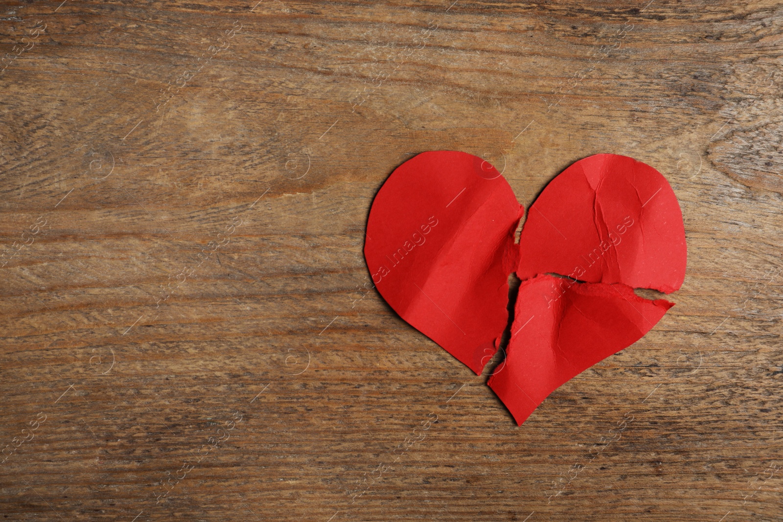 Photo of Torn paper heart on wooden background, top view with space for text. Relationship problems concept