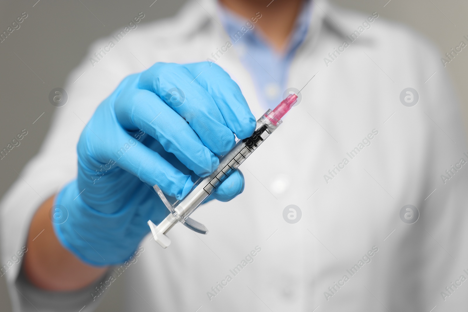 Photo of Doctor holding syringe with needle, closeup view