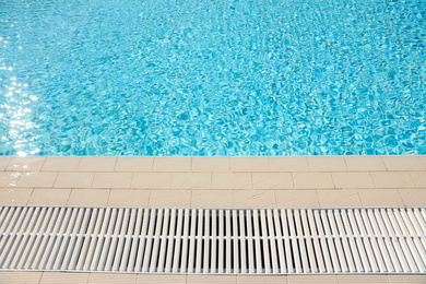 Photo of Edge of swimming pool with clear water on sunny day. Summer vacation