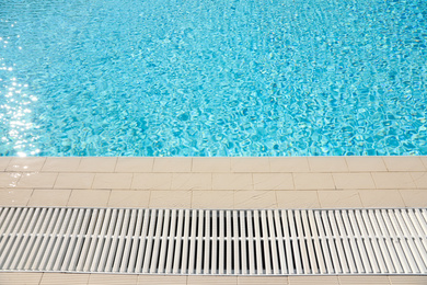 Edge of swimming pool with clear water on sunny day. Summer vacation