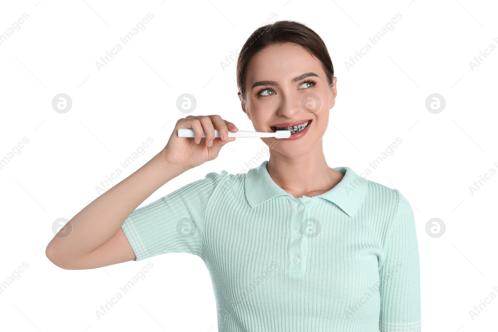 Photo of Young woman brushing teeth with charcoal toothpaste on white background