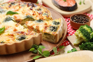 Delicious homemade quiche and ingredients on table, closeup