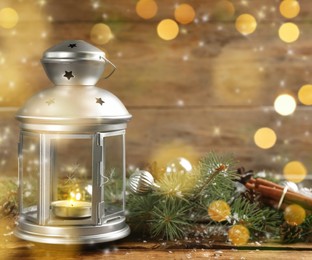 Image of Christmas lantern with burning candle and festive decor on wooden table 