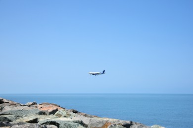 Photo of Modern airplane flying in sky over sea
