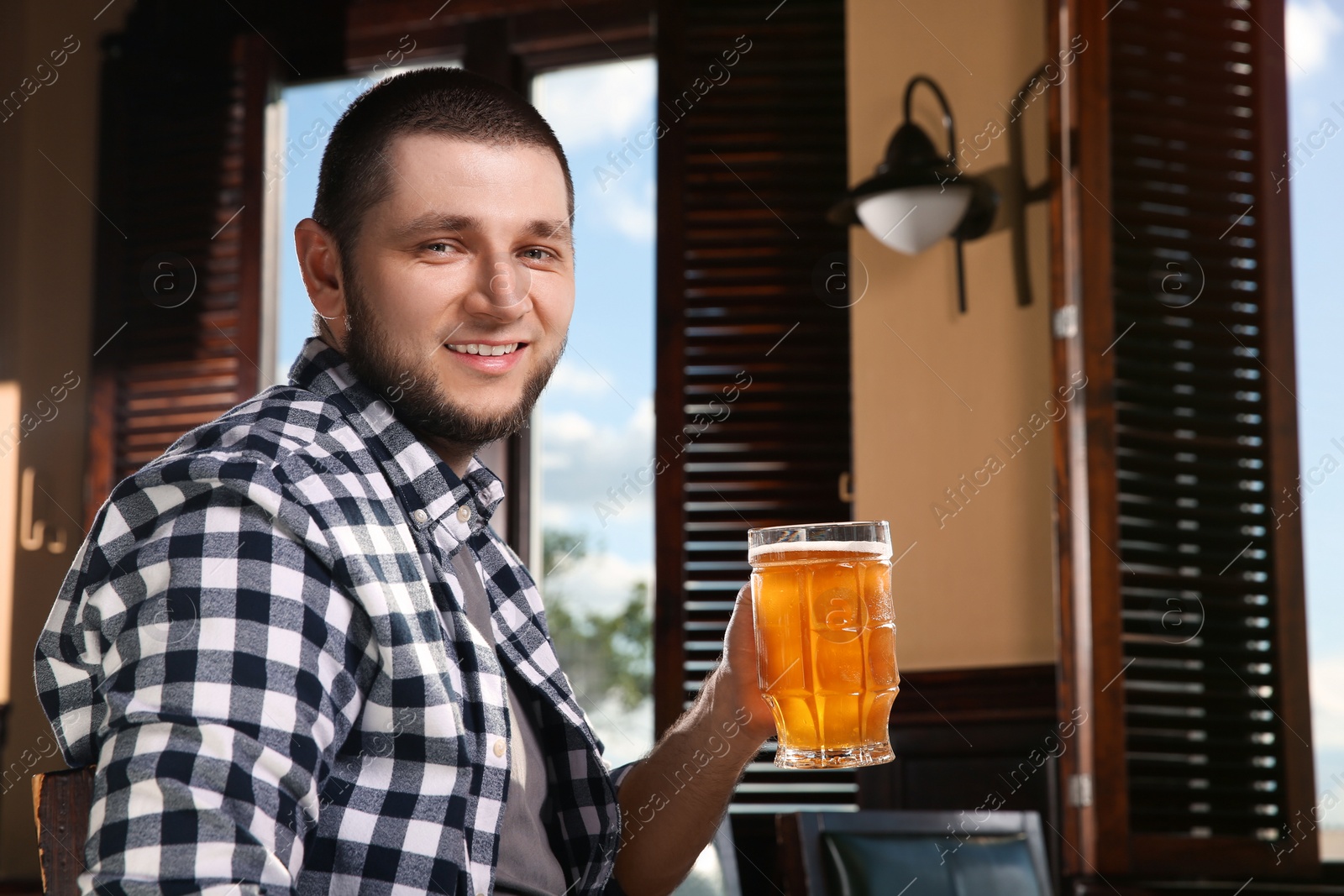 Photo of Man with glass of tasty beer in pub