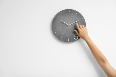 Photo of Woman pointing on clock against white background. Time concept