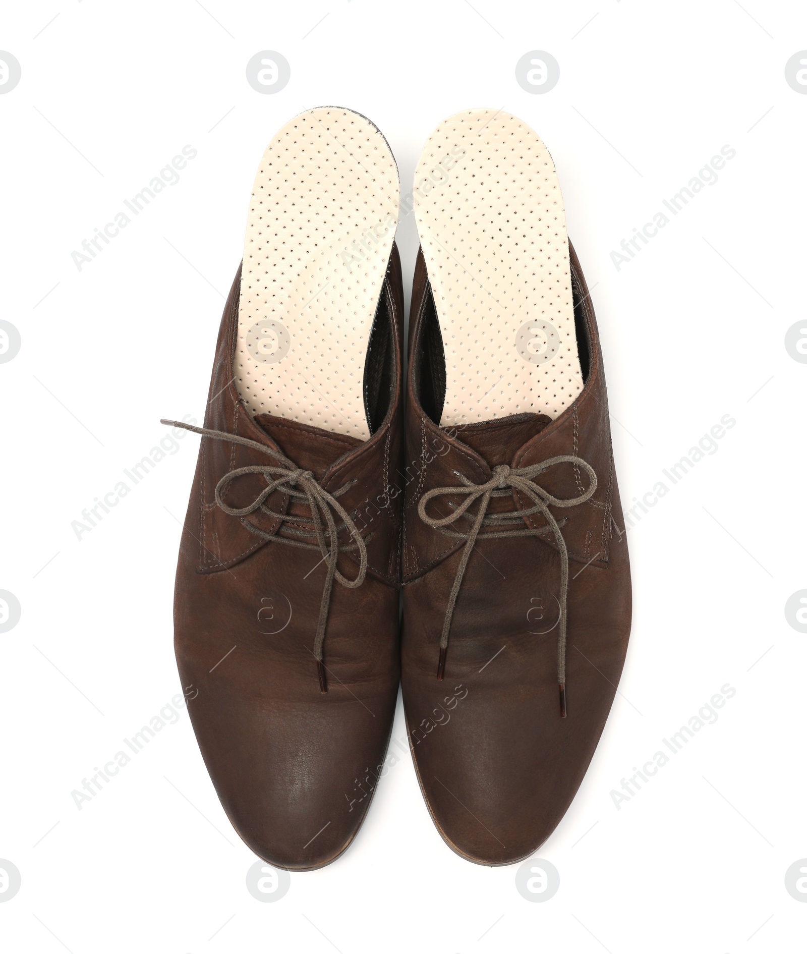 Photo of Orthopedic insoles in shoes on white background, top view