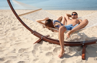 Young lovely relaxing in hammock on beach