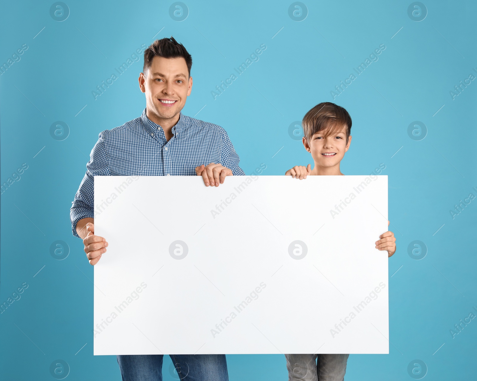 Photo of Dad and his son with empty banner on color background. Space for design