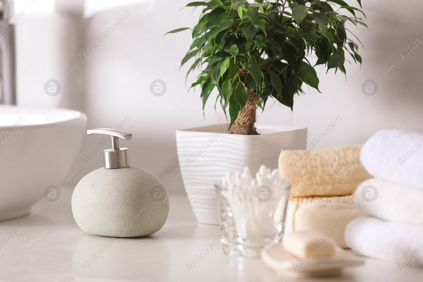 Photo of Composition with soap dispenser and towels on white table indoors