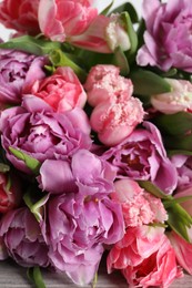 Photo of Beautiful bouquet of colorful tulip flowers on table, closeup