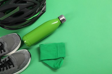 Different sports equipment on green background, flat lay. Space for text