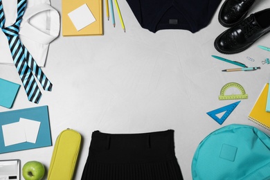 Photo of Flat lay composition with school uniform on light background. Space for text