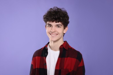 Photo of Portrait of happy teenage boy on violet background