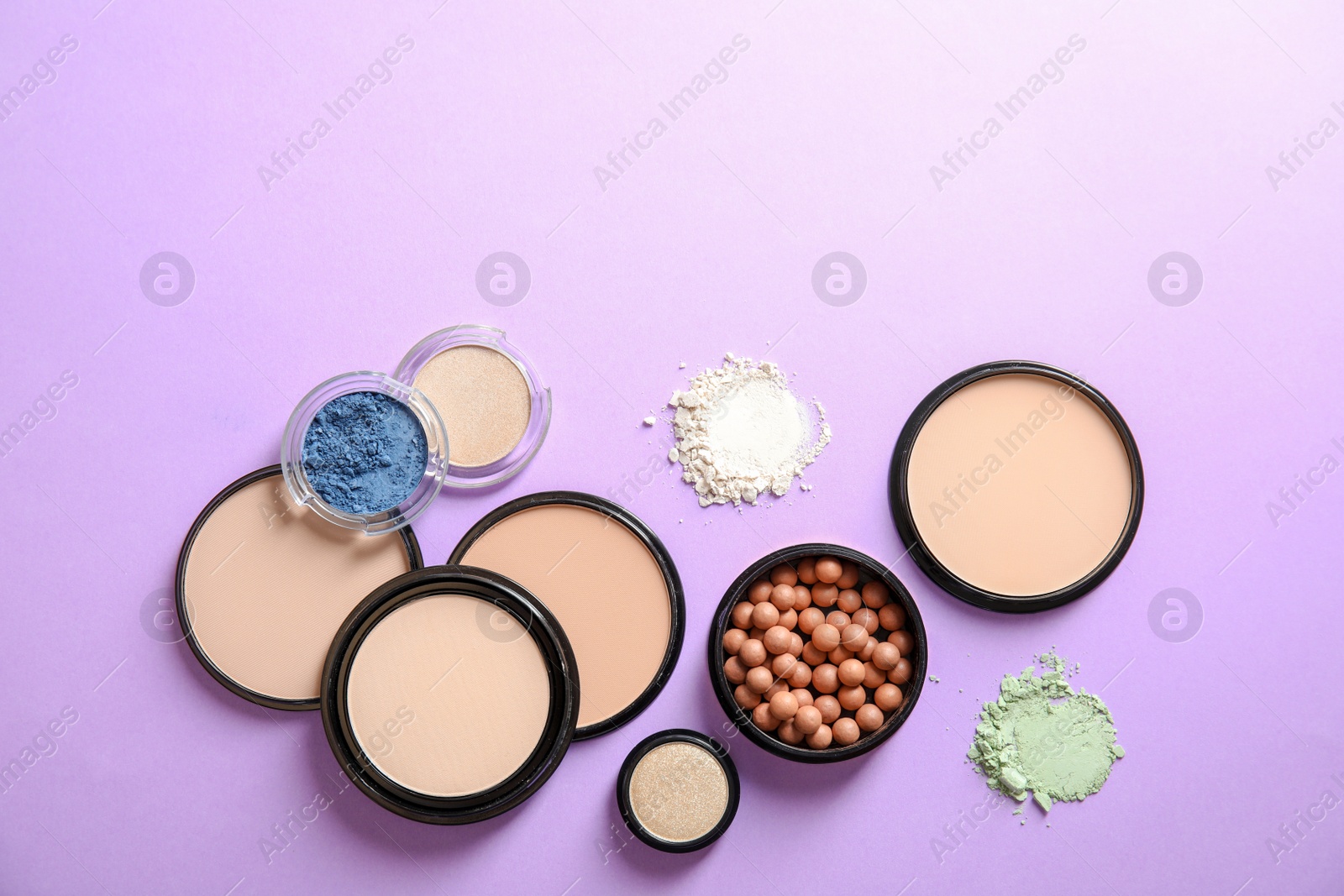 Photo of Flat lay composition with various makeup face powders on color background. Space for text