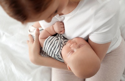 Photo of Mother with her baby on bed, above view