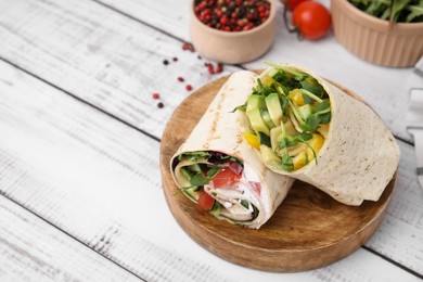Photo of Delicious sandwich wraps with fresh vegetables and peppercorns on white wooden table, space for text