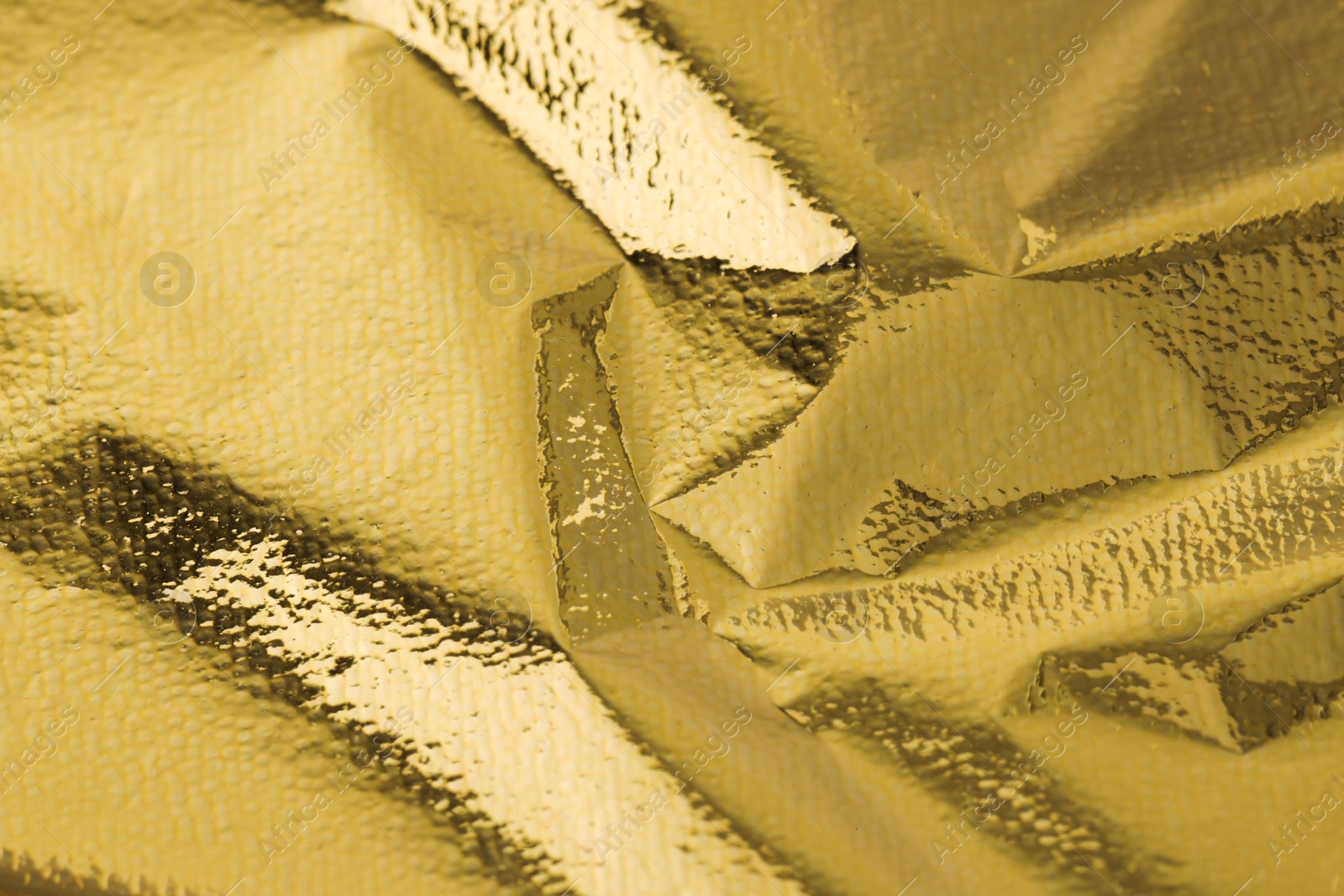 Photo of Edible gold leaf sheet as background, closeup