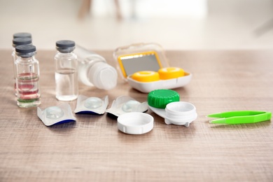 Photo of Contact lenses and accessories on wooden table
